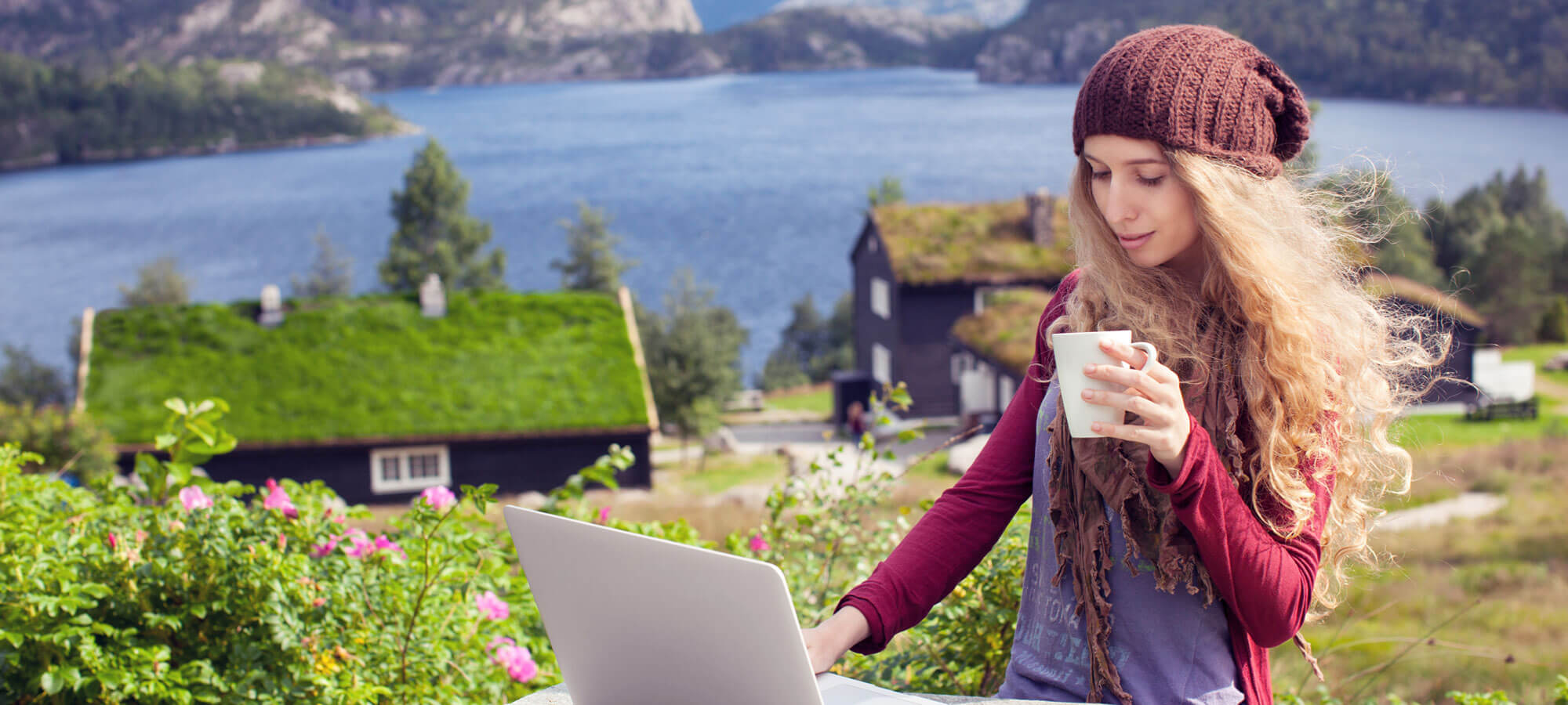Kvinne som sjekker PCen sin ute i naturen