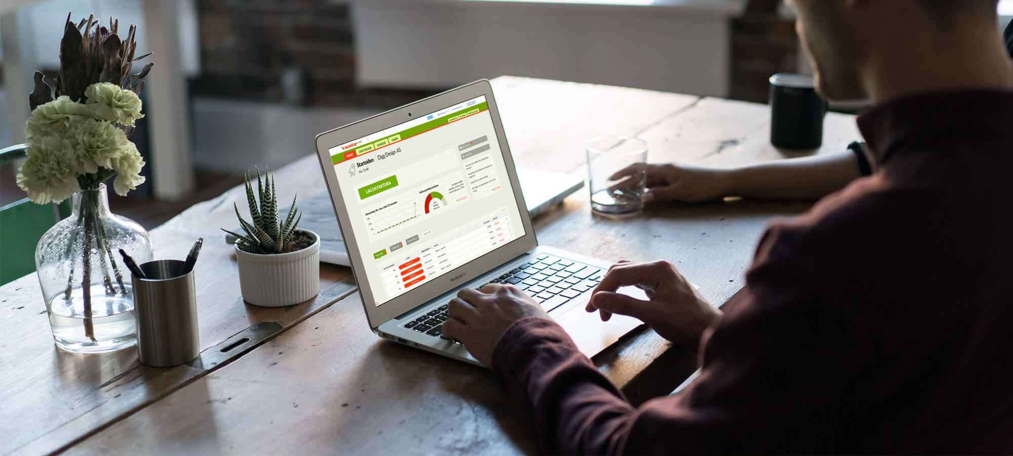 Mann som jobber med Conta Faktura på laptopen